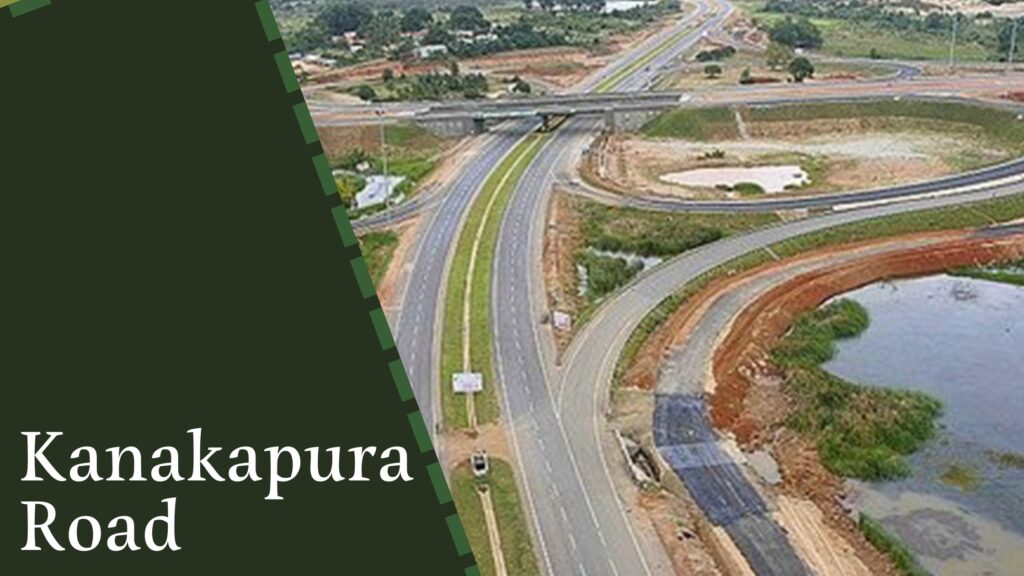 Aerial view of a highway with multiple lanes and an overpass, surrounded by green and brown land, labeled "Kanakapura Road" on the left side, where numerous house construction companies in Bangalore are developing new residential projects.