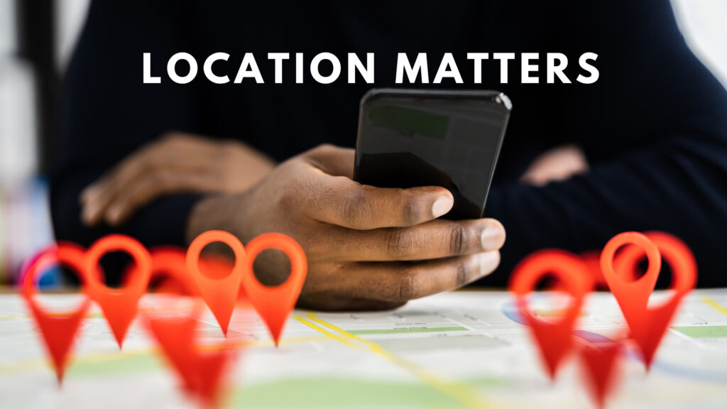 Person holding a smartphone over a map with red location pins, with the text 'LOCATION MATTERS,' highlighting the importance of choosing the right home construction contractors for home construction in Bangalore